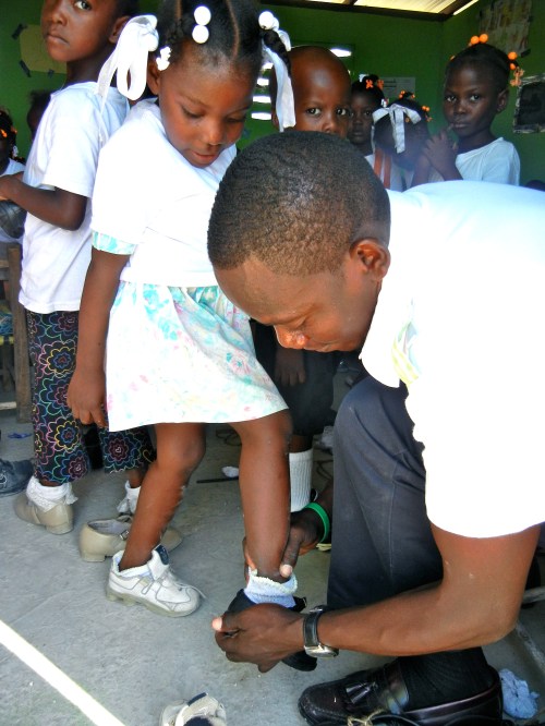 the boss himself fitting shoes on the kids